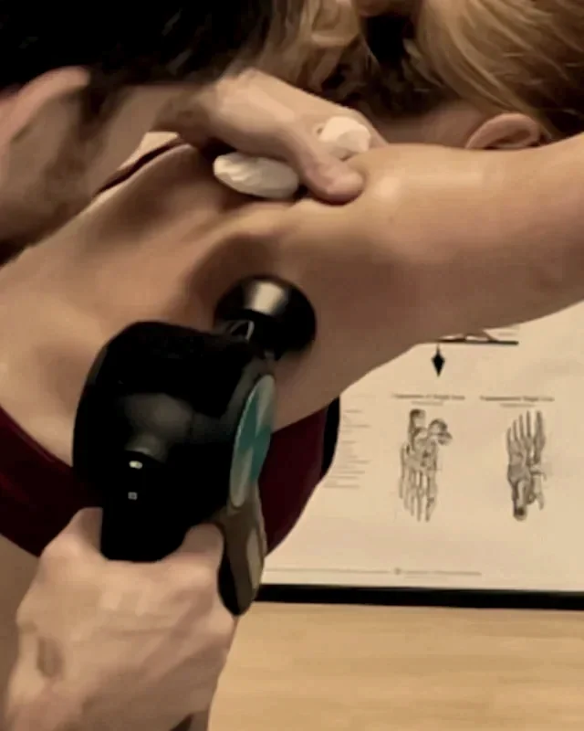 Percussion therapy to the muscles of the mid back at Achieve Chiropractic in Newport News, VA